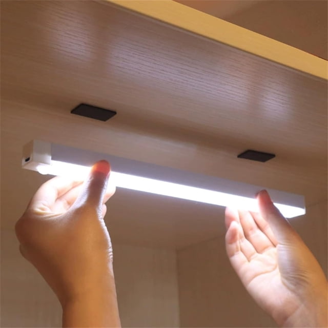 EGNMCR Night Lights, a punch-free smart sensor magnetic rechargeable LED light with motion detection, shown being installed under a wooden shelf. The slim, rectangular design emits bright white light and features a Type-C charging port. Magnetic holders ensure easy attachment. Suitable for hallways, bedrooms, or RV lighting.
