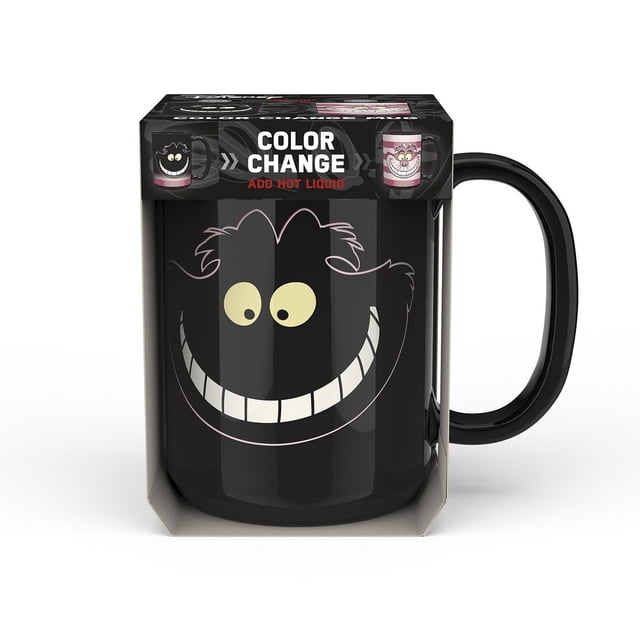 Zak Designs Alice In Wonderland 15oz colour change mug with a black ceramic body featuring the Cheshire Cat's smiling face in pale yellow and white, designed to reveal new artwork when filled with hot beverages, packaged in a box highlighting the color change feature.
