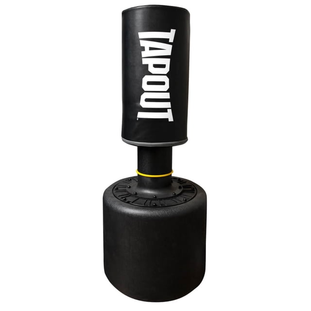 Tapout Free Standing Punching Bag with a black cylindrical padded striking surface featuring the white TAPOUT logo, mounted on a compact black base with a yellow ring at the connection point, suitable for home gyms and small workout spaces.