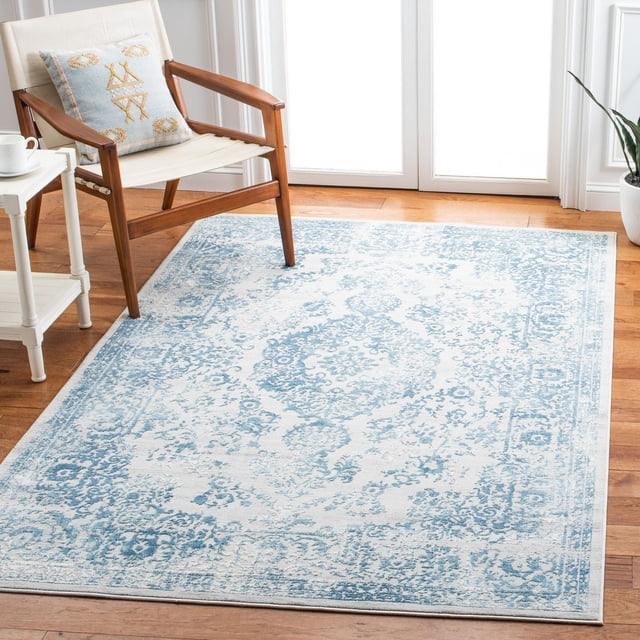 SAFAVIEH Princeton Tapis à Bordure Florale Weldon sur Plancher de Bois Franc dans une Pièce Lumineuse, Présentant un Motif Floral vintage Bleu et Crème avec une Bordure durable, Assorti à un Fauteuil en Bois et à une table d'Appoint Blanche, Convient pour Accentuer un Décor Traditionnel Ou Moderne.