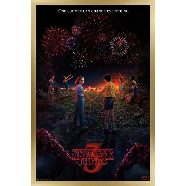 Netflix Stranger Things : Saison 3 - Affiche Murale d'Art Clé Représentant six Enfants Debout sur un Sentier Rocheux la Nuit, Regardant des Feux d'Artifice Rouges, Blancs et Bleus sur une Ville Éclairée. Deux Enfants Se Tiennent la Main au Centre, avec des Bicyclettes et des Arbres à Proximité. l'Affiche Présente le Slogan « un Été Peut Tout Changer » et le logo Rouge Stranger Things 3, Encadré en Bois Clair.