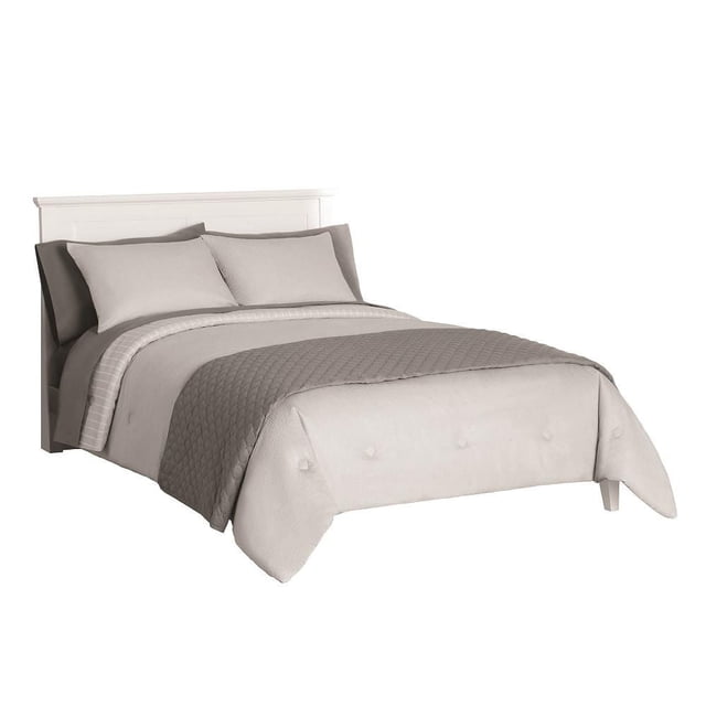 Mainstays 8 piece Bed-in-a-Bag bedding set with a grey solid polyester comforter and two matching shams, a diamond-stitched darker grey coverlet, flat and fitted sheets, and pillowcases on a white bed frame, suitable for layering and machine washable.