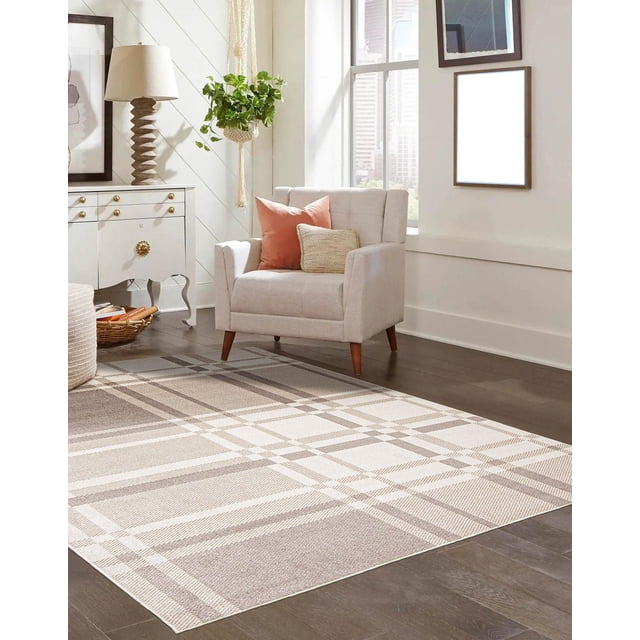 ECARPET Washable Plaid Area Rug & Runner for Kitchen, Bedside, Living Room, Hallway on dark hardwood floors, featuring a low-pile, stain-resistant polyester rug with beige and cream plaid pattern. Positioned in a bright living room with a light grey armchair with coral and beige cushions, white side table with brass knobs, sculpted lamp, hanging green plant, and framed wall art near a large window. Ideal for high-traffic areas and easy to clean by vacuuming without the beater bar.