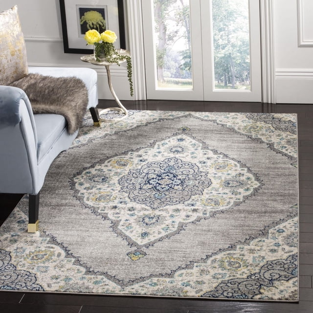SAFAVIEH Madison Frazier Tapis Géométrique Floral pour Aire avec un Motif central de Médaillon Floral en Tons Gris, Bleu et Crème sur Plancher de Bois Franc Foncé, Placé à Côté d'Une Chaise Rembourrée Bleu Pâle avec des Pattes à Pointe Dorée et une Petite table d'Appoint Tenant des Fleurs Jaunes, Conçu pour une Utilisation durable et Facile d'Entretien dans la Déco Maison Contemporaine et Transitionnelle, Convient Aussi comme Tapis d'Accent pour Salons Ou Chambres.