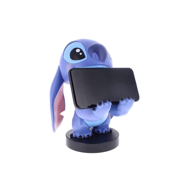 Exquisite Gaming Lilo & Stitch: Stitch Cable Guy Original Controller and Phone Holder is an 8-inch tall blue figure of Stitch holding a black smartphone horizontally with both hands on a round black base, compatible with most smartphones and gaming controllers, often used to organize devices on desks or shelves.