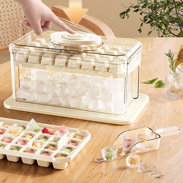 TopLLC Kitchen Accessories 64-lattice press ice tray with a large-capacity ice cube mould, shown in a beige design. The set includes a press lid, ice storage box, and ice shovel. The ice tray is filled with colorful DIY ice cubes, and the storage box contains clear ice cubes. A hand is pressing the lid for easy ice cube release. The setup is displayed on a wooden table with a glass of infused water and greenery in the background.