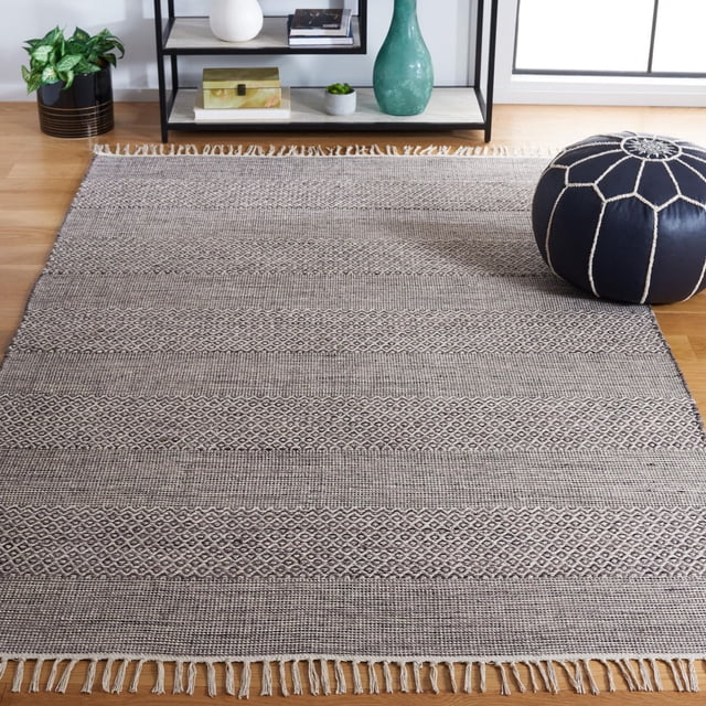 SAFAVIEH Montauk Karlene Tapis en Coton à Rayures Géométriques, Mettant en Vedette du Coton à Tissage Plat avec des Rayures Alternées en Losanges et Tissées dans des Tons Neutres de Sable et de Soleil, Bords à Franges, Exposé sur un Plancher de Bois Franc avec un pouf Surpiqué Noir et une Tablette en Métal Noire, Convient aux décor Côtier et Contemporain.
