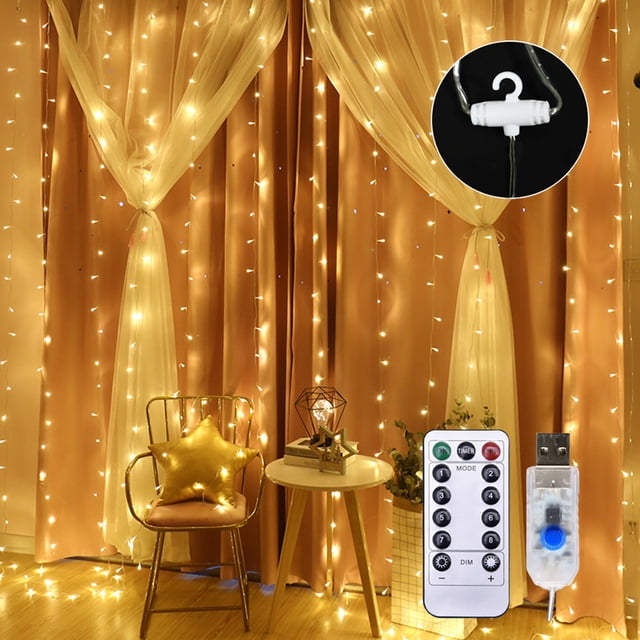 TFixol 10 X 6FT 200LEDs curtain string lights displayed in a warm indoor setting with soft white illumination. The copper wire waterfall lights are hung against curtains, creating a cozy and romantic atmosphere. Includes USB power, remote control, and 8 adjustable light modes. Suitable for outdoor lighting, garden decor, weddings, and parties.