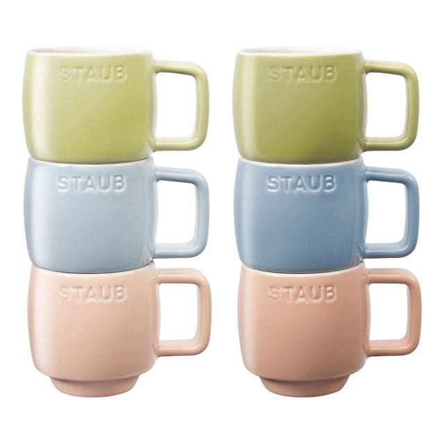 STAUB Ceramique Macaron Espresso Mug Set 100 ml / 6 Piece Mixed Colours. A set of six ceramic espresso mugs in pastel shades of green, blue, and pink, each with an ergonomic handle and the STAUB logo embossed on the surface. The mugs are stackable, temperature-resistant up to 300 °C, and safe for use in the microwave and dishwasher. Ideal for serving espresso, these mugs come in a gift box.