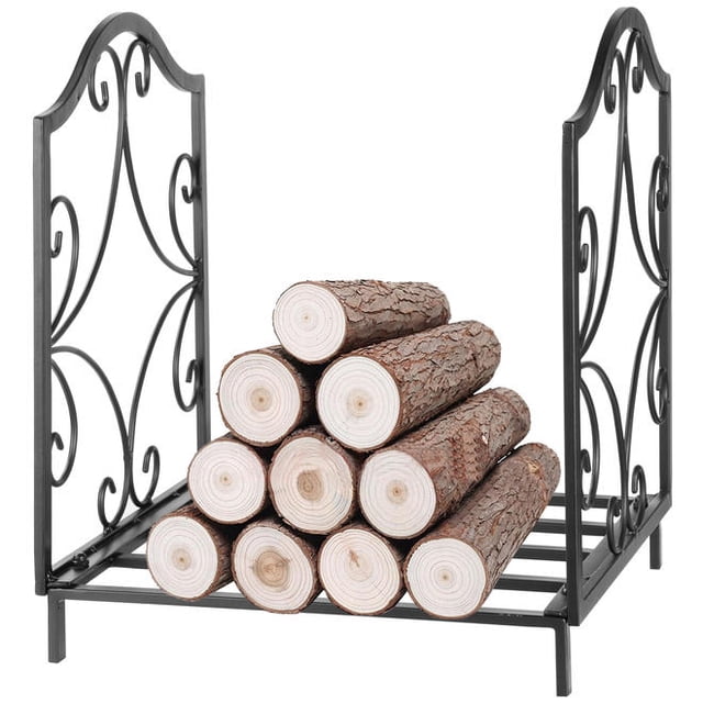 15.6-inch heavy-duty firewood rack log holder by LIVINGbasics, featuring a decorative scroll design on both sides. Made of durable iron with a matte black finish, it holds up to 20kg of firewood. The rack is shown with neatly stacked logs, suitable for indoor or outdoor use near fireplaces or wood-burning stoves. Dimensions are 13.58 inches long, 12.72 inches wide, and 15.55 inches high.