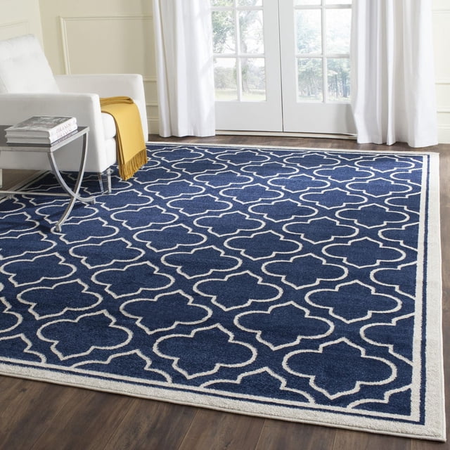 Safavieh Amherst Wilson Tapis Géométrique pour Aire avec Fond Bleu Marine et Motif Trèfle Blanc, construction en Polypropylène Tissée Mécaniquement pour une Utilisation durable Intérieur-Extérieur, Exposé sur Plancher de Bois Franc Foncé Près d'Un Fauteuil Blanc et de Portes en Verre, Idéal pour les Espaces à Fort Passage à la Maison Ou au Bureau.