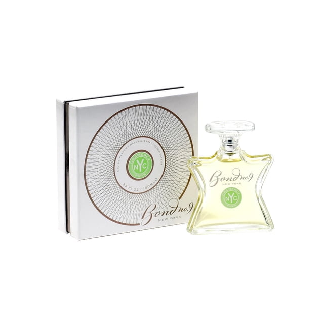 Bond 9 Gramercy Park Unisex Eau de Parfum Spray 100ml with a star-shaped clear glass bottle containing pale yellow fragrance and a clear cap, displayed next to a white box featuring a circular geometric pattern and green Gramercy Park NYC logo, offering a green floral scent with ivy and lily notes ideal for daytime use and suitable for gifting.
