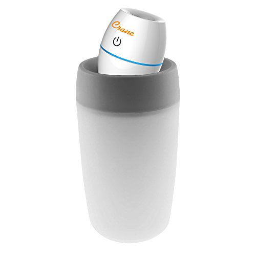 Crane USA Travel Cool Mist Humidifier in white, featuring a compact and lightweight design. The humidifier has a cylindrical base with a grey accent and a tilting nozzle for adjustable mist direction. Ideal for travel, dorms, or offices, it operates quietly and is USB-powered for convenience.
