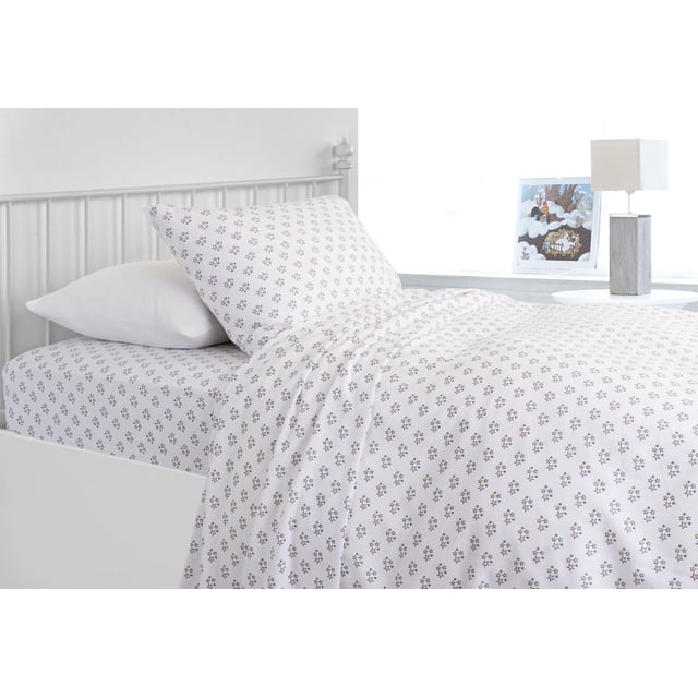Royale Flannel Sheet Sets in white with a small multicolored star pattern, made of 100% cotton flannel, displayed on a white metal bed frame with matching pillowcases and fitted sheet in a bright kids' bedroom with a bedside table, lamp, and framed artwork, ideal for adding warmth and comfort to children's bedding.
