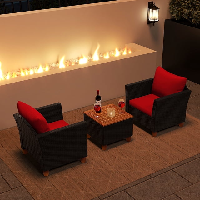 Costway Ensemble de Meubles de Patio en Rotin 3 Pcs, Canapé Rembourré avec Table de Rangement et Dessus en Bois Rouge. Cet Ensemble Comprend Deux Fauteuils en Osier PE Noirs avec Coussins Rouges et une Table Basse Carrée avec Dessus en Bois d'Acacia Massif Qui Fonctionne Aussi comme Boîte de Rangement. le Mobilier Est Exposé sur un Patio avec un Foyer en Arrière-Plan, Créant une Atmosphère Chaude et Invitante. Convient aux porches, patios Ou Jardins.