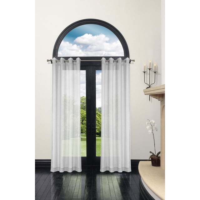 Safdie & Co. Bella Batiste Rideau 86 L Blanc Voilage Filtrant la Lumière Suspendu sur une Tringle Argentée au-Dessus d'Une Fenêtre Cintrée à Cadre Noir et de Portes Vitrées, avec Tissu Infroissable Qui Diffuse Doucement la Lumière Naturelle dans une Pièce avec des Planchers de Bois Franc Sombres, un Foyer beige avec un Porte-Bougie en Métal Noir, et une Plante d'Orchidée Blanche dans un pot Brun, Convient à l'Étagère Ou à l'Utilisation Autoportante.