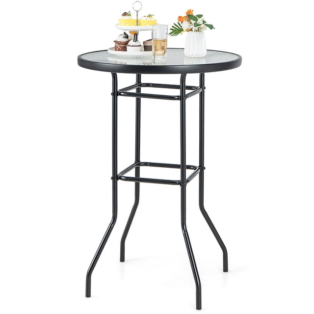 Patiojoy Round Glass Top Patio Table measuring 27 inches by 27 inches, featuring a water ripple tempered glass tabletop and a heavy-duty black powder-coated metal frame. The table includes non-slip foot pads for stability and smooth edges for safety. Suitable for outdoor and indoor use, such as patios, gardens, or living rooms. The table is shown with decorative items, including a vase, a glass, and a dessert stand.