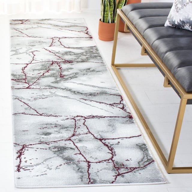 SAFAVIEH Craft Paul Abstract Marble Area Rug runner with swirling abstract marble pattern in white, grey, and red tones, made from soft synthetic yarns for durability and comfort, placed on a white floor beside a gold metal-framed black cushioned bench and a potted snake plant in a bright room.