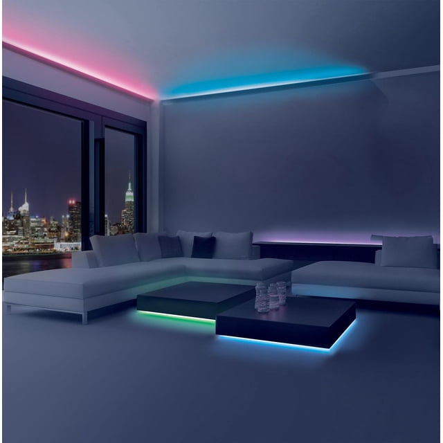 Merkury FlexGlo TG Bande Lumineuse Multicolore Flexible Installée à l'Intérieur le Long des Bords de Plafond et sous les tables Basses Noires dans un Salon Moderne avec des Vues Nocturnes sur la Ligne d'Horizon de la Ville, Montrant un Éclairage d'Ambiance DEL Multicolore en Tons Rose, Bleu, Vert et Violet, Idéal pour Rehausser les Espaces du Porche, de la Terrasse Ou de la Cuisine.