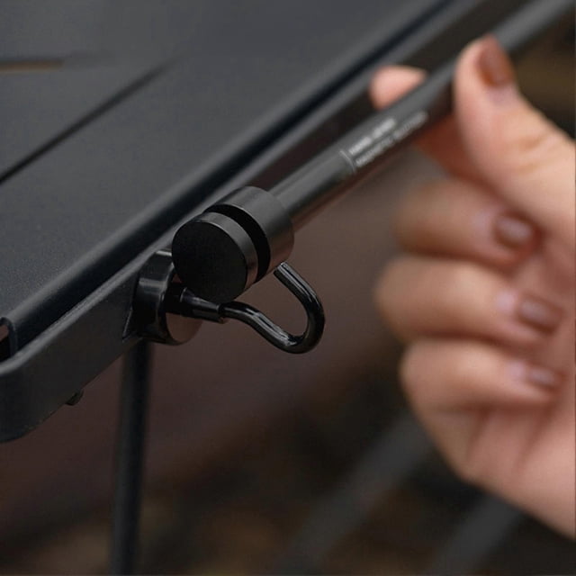 Adjustable curtain rods for windows with a magnetic hanging design, shown in a close-up view. The rod is crafted from stainless steel and aluminum alloy, featuring a black finish and a magnetic suction hook securely attached to an iron surface. Ideal for metal-framed windows or doors, this portable and durable rod offers easy installation without drilling, making it suitable for both indoor and outdoor use.