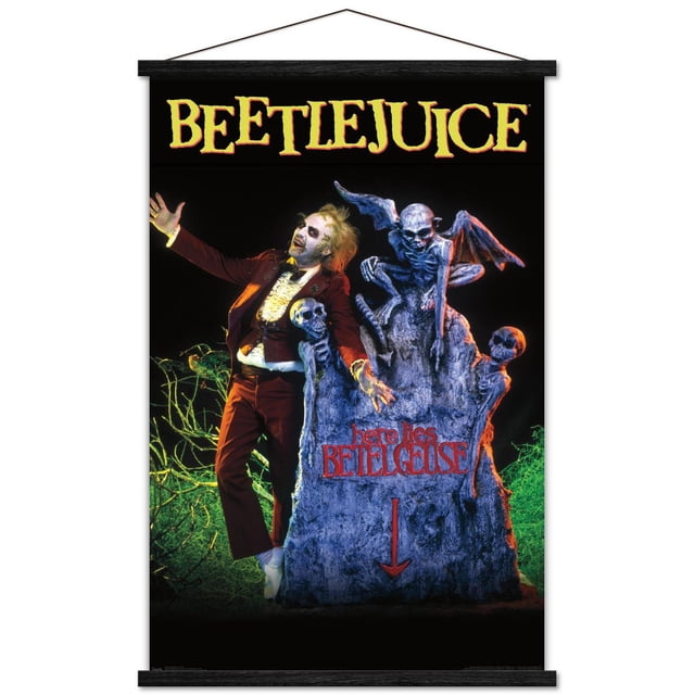 Beetlejuice - Affiche Murale de Tombe, 22,375 Pouces x 34 Pouces Affiche Encadrée Présentant un Fond Sombre avec une Grande Pierre Tombale Grise Inscrite en Rouge avec « Here lies Beelgeuse » et une Flèche vers le Bas. la Pierre Tombale Est Décorée de Figurines Squelettiques et d'Une statue de Gargouille Ailée. une Figurine en Complet Bourgogne avec une Chemise Blanche à Volants Se Tient avec des Bras Ouverts à Côté de la Pierre Tombale. Cette Oeuvre Murale à Thème Gothique