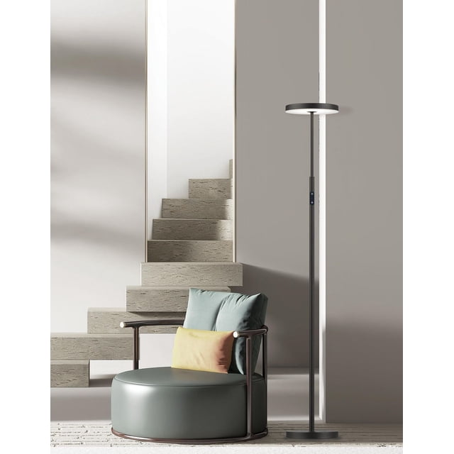 Francine Floor Lamp - 30W - Sandy Black - White Acrylic Diffuser with a slim sandy black metal pole and circular white acrylic diffuser, positioned beside a modern round armchair with teal and yellow cushions in a minimalist room featuring a floating stone staircase, providing energy-efficient LED lighting ideal for office or bedroom tasks.