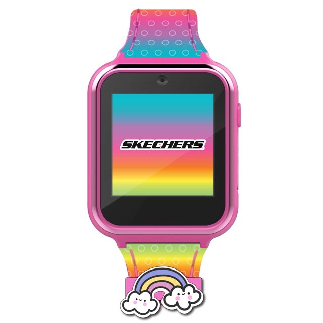 Skechers Montre Interactive à Écran Tactile avec Caméra dans un Boîtier en Plastique Rose avec un Affichage Numérique Carré Affichant le logo Skechers sur un Fond Dégradé Arc-en-Ciel, Jumelée à un Bracelet en silicone Multicolore Présentant des Motifs de Cercles Blancs et un Charme Arc-en-Ciel avec des Nuages Souriants, Convient comme Montre Intelligente d'Initiation pour Enfants avec Écran Tactile et Fonctions d'Appareil Photo.