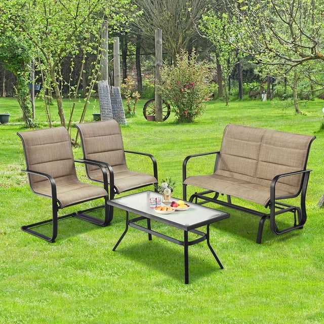Costway Ensemble de Mobilier de Patio Extérieur 4 Pcs avec une Causeuse à Bascule pour 2 Personnes, Deux Chaises de Salle à Manger de Patio à Mouvement à Ressort et une table Basse en Verre Trempé. l'Ensemble Comprend des Sièges Rembourrés Bruns, des Accoudoirs Ergonomiques et des Cadres en Acier Noir, Disposés dans une Cour Arrière Vibrante. Idéal pour la Détente et les Réceptions en Plein Air.
