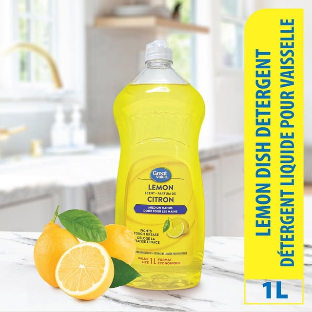 Great Value Lemon Scented Dishwashing Liquid in a 1L clear plastic bottle with yellow liquid, labeled for lemon scent, mildness on hands, and grease-cutting power, placed on a white marble kitchen counter beside fresh whole and halved lemons with green leaves in a bright kitchen setting.