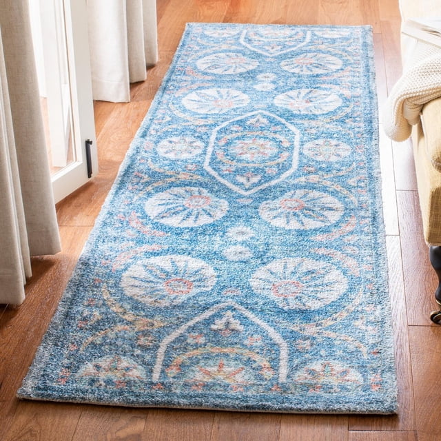 Safavieh Saffron Jaslyn Bordered Oriental Area Rug on hardwood floor, featuring a soft cotton weave with distressed blue background and pastel floral medallion patterns within a bordered frame, suitable as an accent rug for hallways or living spaces.