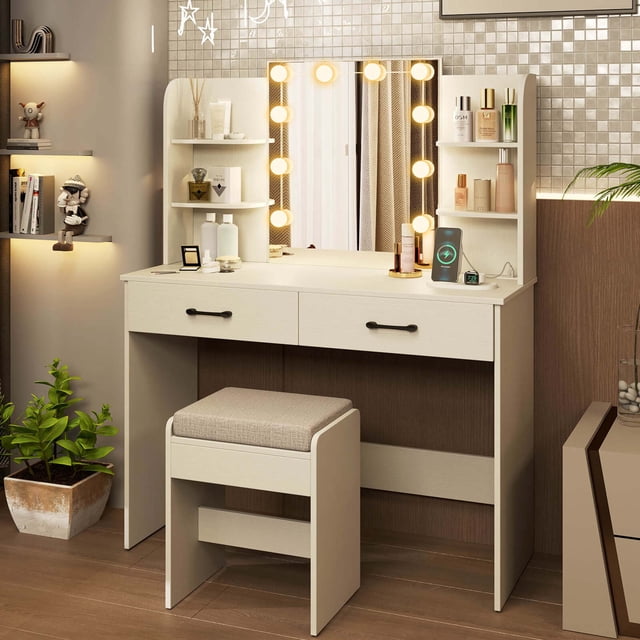 Costway Coiffeuse avec Miroir Éclairé Station de Recharge Lumières DEL à 3 Couleurs à Intensité Réglable Blanc. Cet Ensemble de Coiffeuse Comprend un Bureau en MDF Blanc et un Bureau en Bois d'Ingénierie avec une Station de Recharge Intégrée Comprenant 2 Prises CA, 1 port USB et 1 port Type‐C. le Miroir Éclairé à DEL HD Offre 3 Réglages de Couleur Réglables : Jaune Chaud, Blanc Chaud et Blanc Froid, Contrôlé par Boutons Tactiles. le Bureau Offre un Grand Rangement avec 4 Étagères Ouvertes et 2 Tiroirs, Complété par un Tabouret Rembourré Assorti. Dimensions : 42,5 x 16 x 53