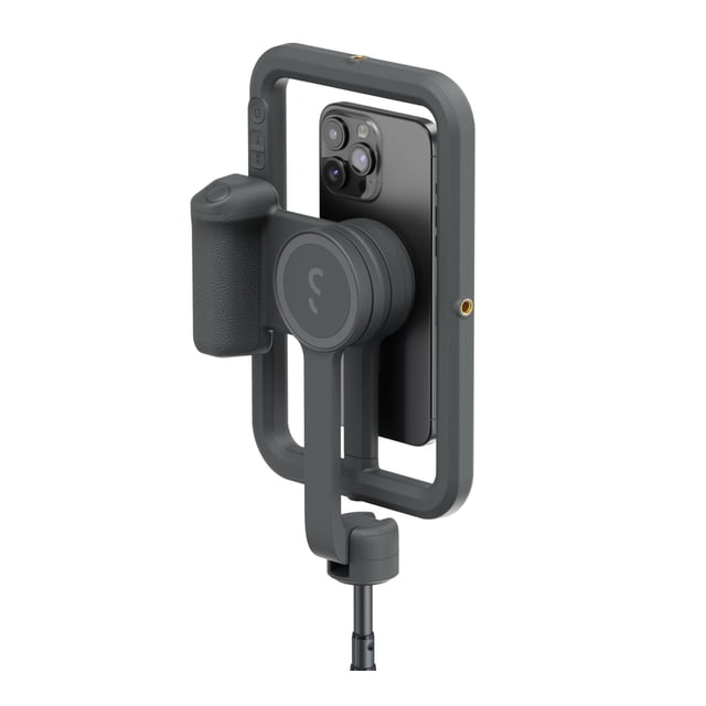 ShiftCam SnapCreator Kit Pro Midnight showing a dark gray SnapGrip Pro ergonomic camera grip with textured handle attached to a rectangular frame holding a black smartphone with triple rear cameras, featuring integrated control buttons and a mounting point for tripod or stand, ideal for mobile content creation and professional lighting.