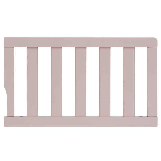 Dream On Me Universal Convertible Crib Toddler Guard Rail in soft pink solid wood with vertical slats and rounded edges, measuring 20 by 12 by 12 inches, designed to convert compatible cribs into toddler beds to prevent falls and ensure toddler safety.