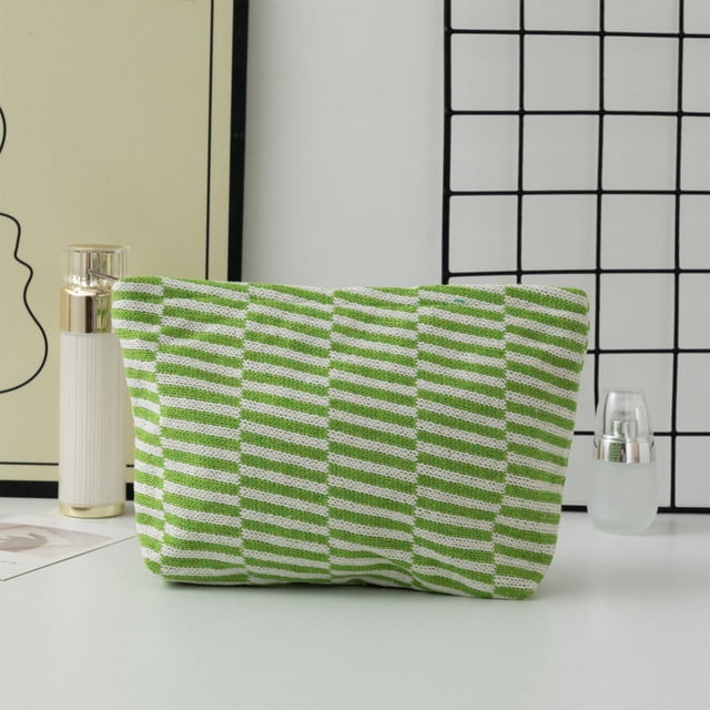 EGNMCR Closet Organizers and Storage Woolen Knitted Bag Striped Color-blocked Cosmetic Bag. This green polyester makeup pouch features a striped color-blocked design with a soft knitted yarn texture. Measuring 25x17x6cm (9.84x6.69x2.36 inches), it offers spacious storage for cosmetics, stationery, or other small items. The elastic material allows for slight expansion, making it versatile for daily use. Displayed on a minimalist surface with a grid-patterned background.