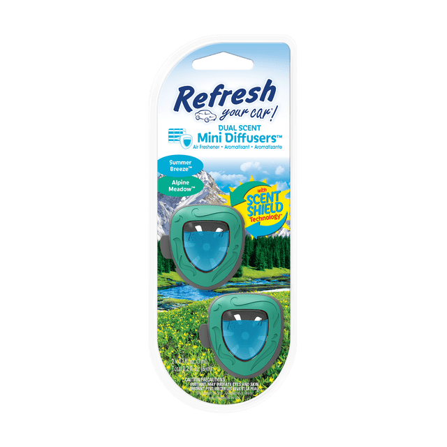Refresh Your Car Mini Diffuser Car Air Fresheners, Alpine Meadows / Summer Breeze Scent, 2 Pack, showing two green vent clip diffusers with blue shield-shaped scent reservoirs and embossed leaf patterns, set against an alpine meadow background with mountains and a river, featuring Scent Shield Technology for long-lasting fragrance.