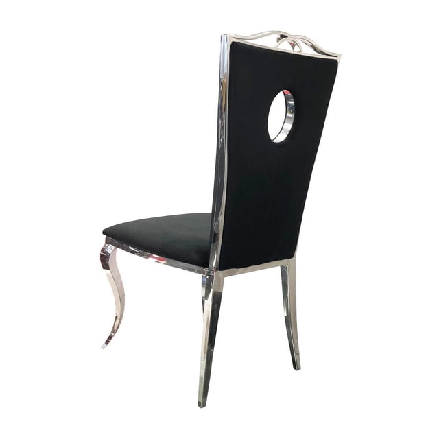 Canadian Chaise de Salle à Manger Bella Argentée (Ensemble de 2) Présentée sous un angle 3/4 Arrière avec un Siège et un Dossier en Tissu Velours Noir avec une Découpe Circulaire. Elle a des Pieds en Acier Inoxydable Fini Miroir, Courbée à l'Avant et Droite à l'Arrière, Mêlant styles Modernes et Traditionnels. Convient aux Sièges de Cuisine et de Salle à Manger et aux Sièges Occasionnels Élégants dans les Aires de Vie.