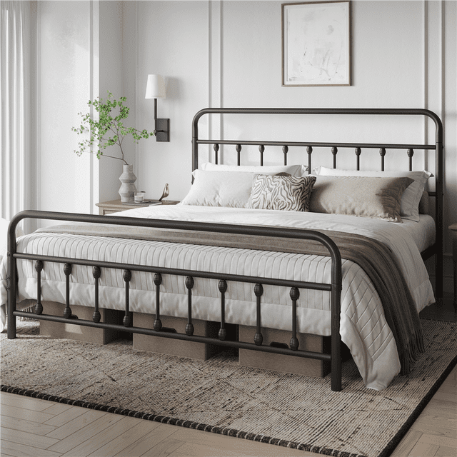 Fullfurnique Classic Iron Platform Bed with High Headboard and Footboard, King, Black, featuring a black powder-coated metal frame with curved spindle details on the tall headboard and footboard. The platform bed supports a king mattress with white and beige bedding and decorative pillows. It offers 12.6 inches of under-bed storage space with visible boxes beneath. Displayed in a bright bedroom with white walls, a side table, vase, and wall-mounted lamp, this durable metal platform bed frame suits farmhouse and rustic interiors.