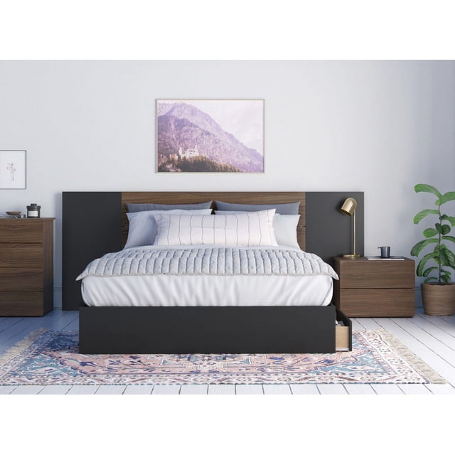 Onyx 4 Piece Bedroom Set, Walnut and Black with a twin bed featuring a walnut and black headboard with extension panels, quilted light gray bedding, and three under-bed storage drawers on metal slides. Includes matching walnut two-drawer nightstand and chest, placed on a patterned area rug in a bright minimalist room with white walls and mountain artwork above the bed.