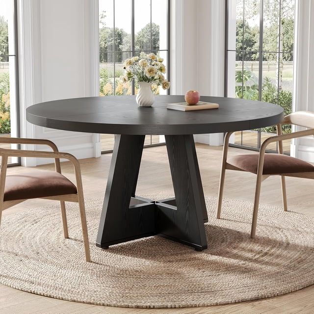 Tribesigns Farmhouse Dining Table, 47-inch round table with a rustic black finish, ideal for seating up to four people. Featuring a sturdy metal frame and MDF board top, it is suitable for dining, crafting, or homework sessions. Positioned on a woven rug in a bright dining room with large windows and wooden chairs.