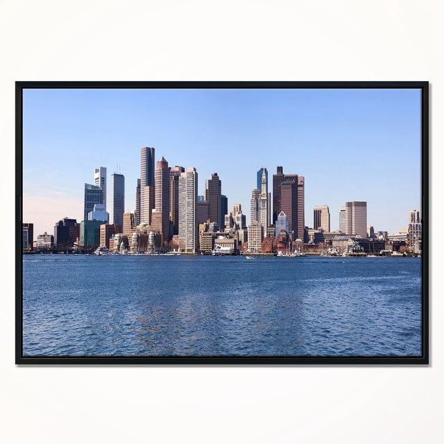 Design Art Boston Skyline Panorama Framed Canvas Art Print featuring a panoramic view of Boston's skyline with high-rise buildings under a clear blue sky, printed on fade-resistant canvas stretched over a 1-inch wood sub frame with a black floating frame, ready to hang as wall art.