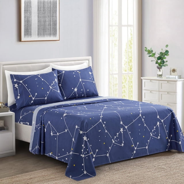 Marina Decoration Ultra Soft Silky Deep Pocket Rich Printed Bedding Rayon from Bamboo All Season Sheet Set with Pillowcases in navy blue featuring white and yellow star asterism constellation pattern, made of 85% polyester and 15% rayon from bamboo, displayed on a bed with white headboard in a bright room with natural light and a white dresser with a green plant.