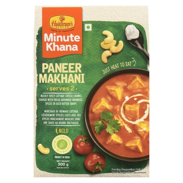Haldiram RTE Paneer Makhani pouch showing a green and orange package with creamy tomato-based curry and soft paneer cubes in a bowl, garnished with cilantro and cream swirl, alongside cashew nuts and fresh tomatoes, labeled mild, ready to heat and eat, 300g net weight, product of India.