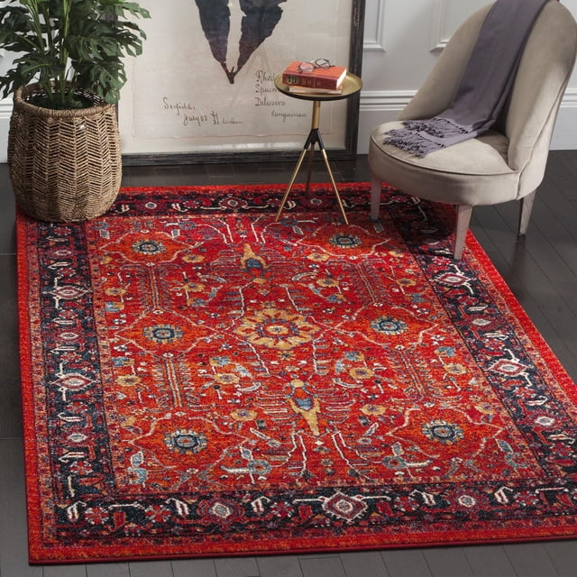 Safavieh Tapis Traditionnel Vintage Hamadan Vinal Mettant en Vedette un Champ Rouge Vif avec des motifs Floraux et Géométriques Persans Complexes en Bleu, Or et Crème, Encadré d'Une Bordure Bleu Marine Foncé. Installé sur des Planchers de Bois Franc Sombres, le Style de l'Aire Comprend une Chaise Rembourrée beige Drapée d'Un Jeté Gris, une table d'Appoint à Trépied Doré avec des Livres et des Lunettes, et un Panier Tissé avec une Plante Verte. Ce Tapis d'Accent durable Ajoute une Touche Vintage et de la Chaleur aux Espaces de Vie Modernes et Convient comme Pièce