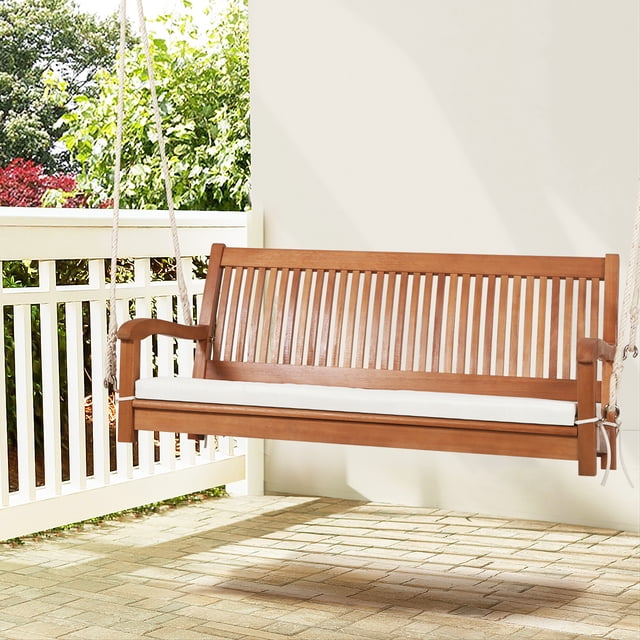 Gymax 2-Seat Patio Hanging Wooden Porch Swing Bench with Cushion and Hanging Ropes. Made of eucalyptus wood with a natural finish, this swing features a slatted backrest, curved armrests, and a soft padded cushion for comfort. Includes two durable hemp ropes with S-shaped hooks for secure hanging. Suitable for porches, gardens, or swing racks. Dimensions: 54.5'' x 24.5'' x 23.5'' (L x W x H).