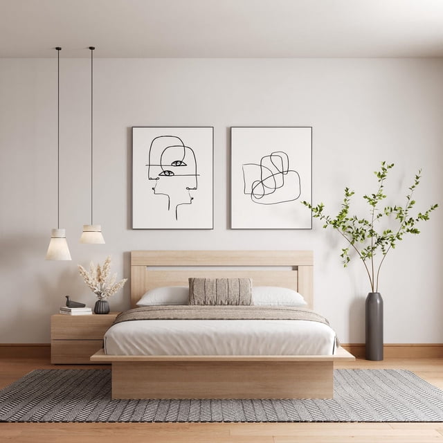 Nexera Malibu 3-piece Bedroom Set with a queen platform bed in light wood featuring a minimalist headboard and concealed plinth base creating a floating effect. Includes a matching 2-drawer nightstand with metal slides on the left. The bed is styled with white linens, a beige throw, and a textured lumbar pillow. Two black line art prints hang above on a neutral wall. A tall gray vase with green branches stands on the right, and two pendant lights hang on the left. The set sits on a gray patterned rug over light hardwood flooring, exemplifying modern, minimalist bedroom furniture designed for easy assembly and versatile decor.