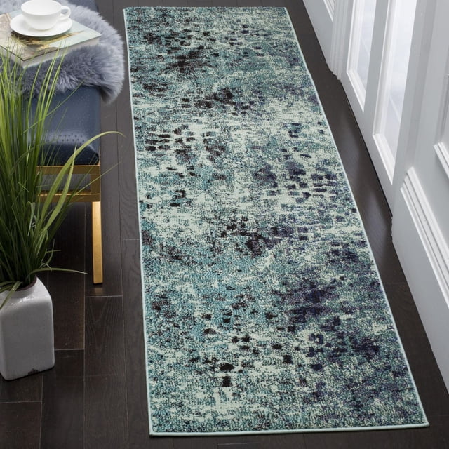 Safavieh Monaco Driskoll Abstract Area Rug runner with a power-loomed polypropylene pile in an abstract blue and black pattern on a light background, placed on dark hardwood flooring near a white door and a blue bench, ideal for adding Bohemian-chic style to narrow hallways or entryways.