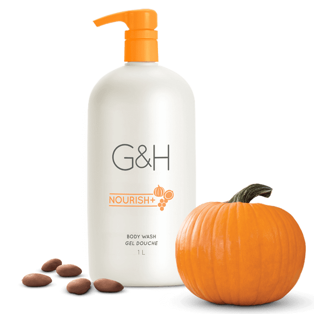 Amway G&H Nourish+ Gel Douche – Bouteille de 1 L avec Corps Blanc et Distributeur à Pompe orange. l'Étiquette Présente le logo G&H et la Marque Nourish+ avec une Icône de Citrouille orange et de Raisin. la Bouteille Est Accompagnée d'Une Petite Citrouille et de Graines Brunes Dispersées, Mettant en Valeur Ses Ingrédients Naturels et Ses Propriétés Hydratantes.