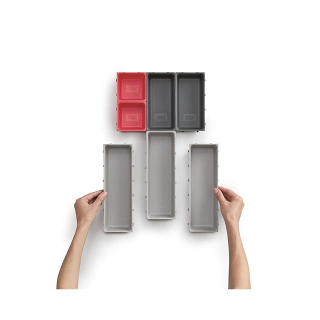 Joseph Joseph Ensemble Organisateur de Tiroirs DUO 7 Pcs avec Plateaux Modulaires Emboîtables en Rouge, Gris Foncé et Gris Pâle, Montré par-Dessus sur Fond Blanc, Deux Mains Tenant de Longs Plateaux Démontrant une Disposition Personnalisable Idéal pour Organiser des Couverts, des Ustensiles, de la Papeterie Ou des Fournitures d'Artisanat.