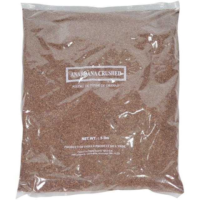 Anardana Crushed Pomegranate Seeds Powder, 5lb, packaged in a clear plastic bag showcasing the fine, brown crushed seeds. The label includes product details in English and French, indicating it is a product of India. Known as a super fruit, it is antioxidant-rich and ideal for garnishing salads, desserts, or adding to soups and chutneys.