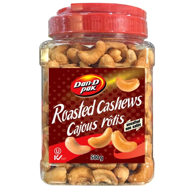 Dan D Pak Unsalted Cashew in a clear plastic jar with a red screw-on lid, containing whole roasted cashews. The red label displays the Dan D Pak logo, 'Roasted Cashews Cajous rôtis,' 'unsalted non salés,' 500 g weight, and kosher certification, suitable as a low-sodium snack or nut topping.